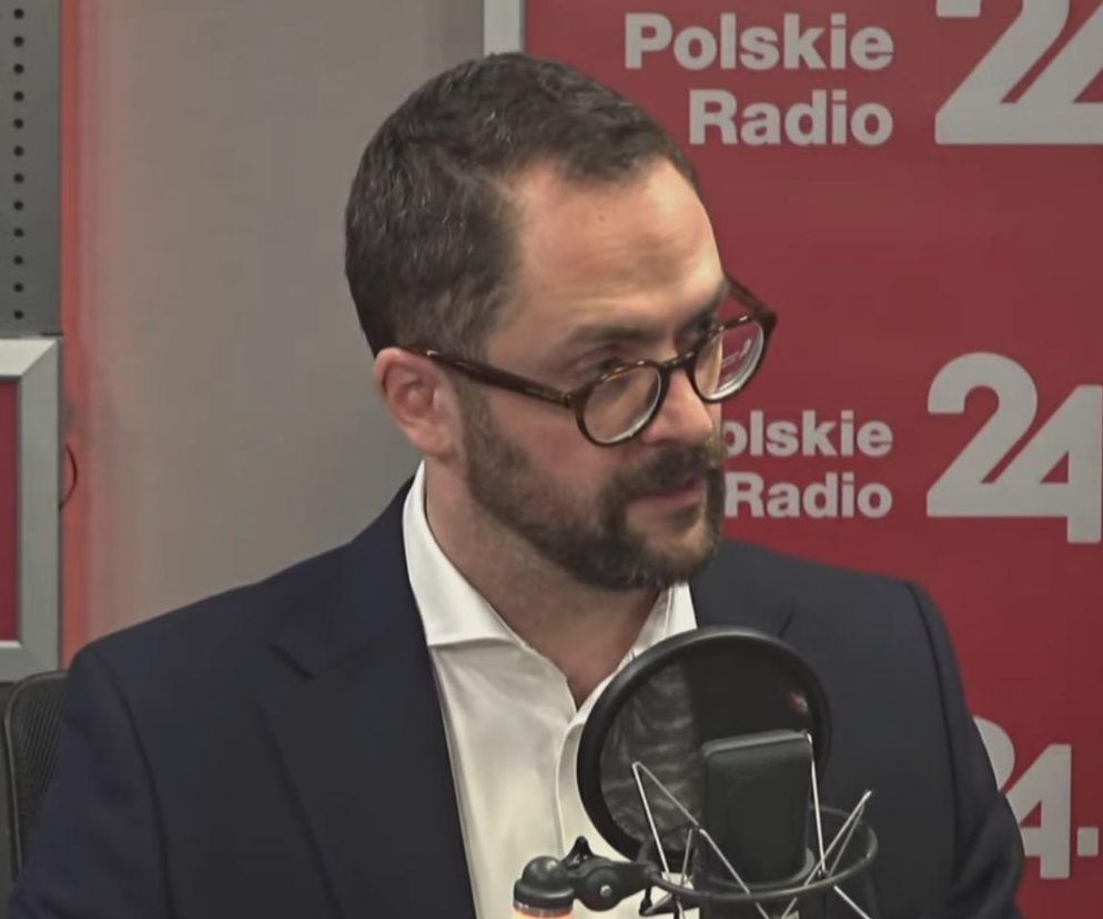 Paweł Bliźniuk, poseł Koalicji Obywatelskiej, w okularach i garniturze, siedzący przed mikrofonem z logo Polskiego Radia 24. Zdjęcie ilustruje kontekst jego wyznania o chorobie nowotworowej i apelu o profilaktykę, o czym przeczytasz więcej na Poradnik Zdrowie.