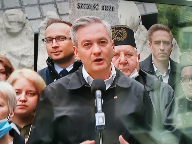 Robert Biedroń na tle religijnego hasła