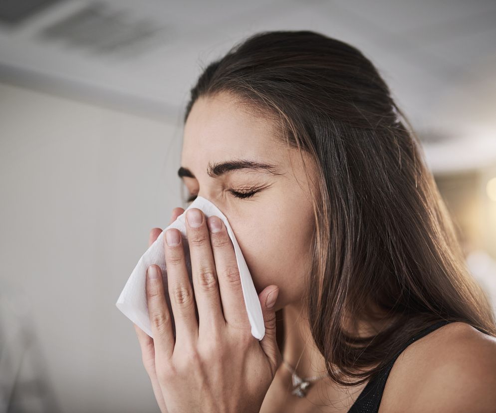 kobieta wydmuchująca nos z powodu alergii