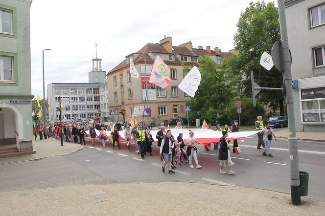 Uczestnicy marszu nieśli kolorowe transparenty z hasłami promującymi wartość życia od poczęcia oraz kilkumetrową flagę Polski