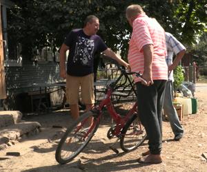 Rolnicy. Podlasie. Andrzej wymienia dziurawą dętkę w rowerze Gienka. Pomaga mu Sławek