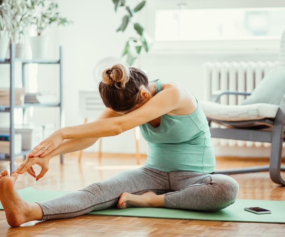 Kobieta rozciąga się na macie