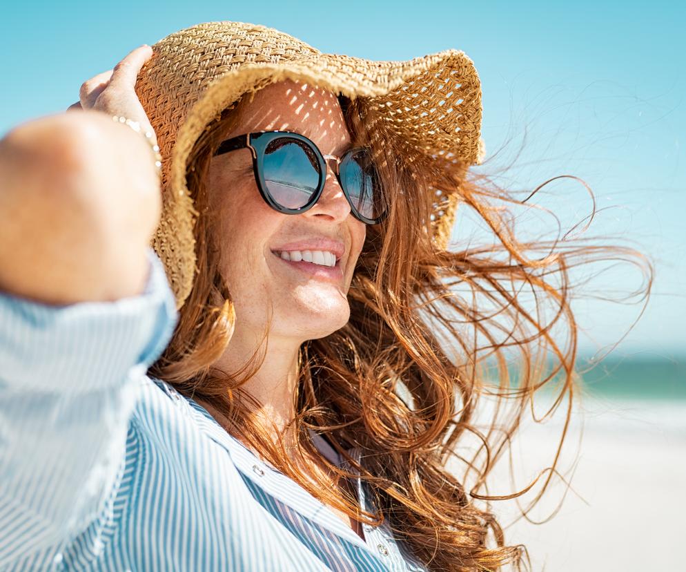 Uśmiechnięta kobieta w okularach przeciwsłonecznych