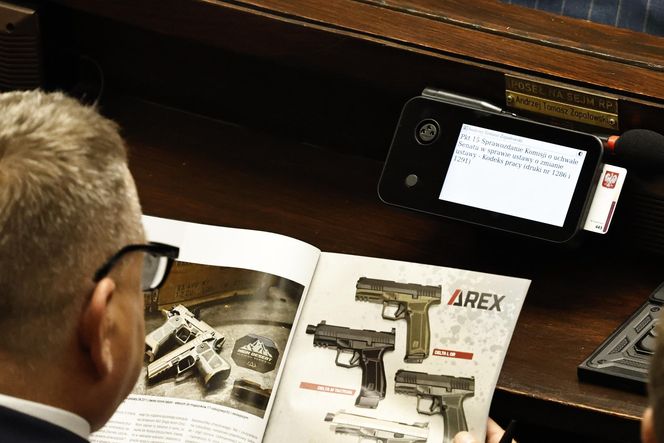 W  czasie obrad Sejmu poseł przeglądał katalog z bronią