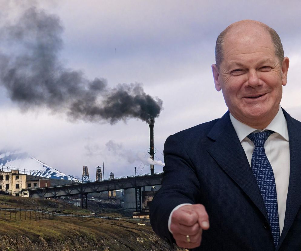 Uśmiechnięty Olaf Scholz i kopalnia z dymiącym kominem