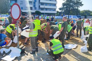 ieszkańcy w pocie czoła układają worki z piaskiem i zabezpieczają swoje budynki