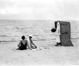 Plażowicze podczas wypoczynku przy wiklinowym koszu plażowym.