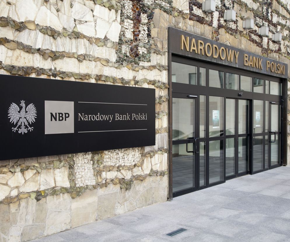 Siedziba Narodowego Banku Polskiego z widocznym logo NBP i napisem Narodowy Bank Polski na elewacji wykonanej z kamienia. Przed wejściem do budynku widoczne są drzwi wejściowe. O prognozach inflacji na portalu Super Biznes.