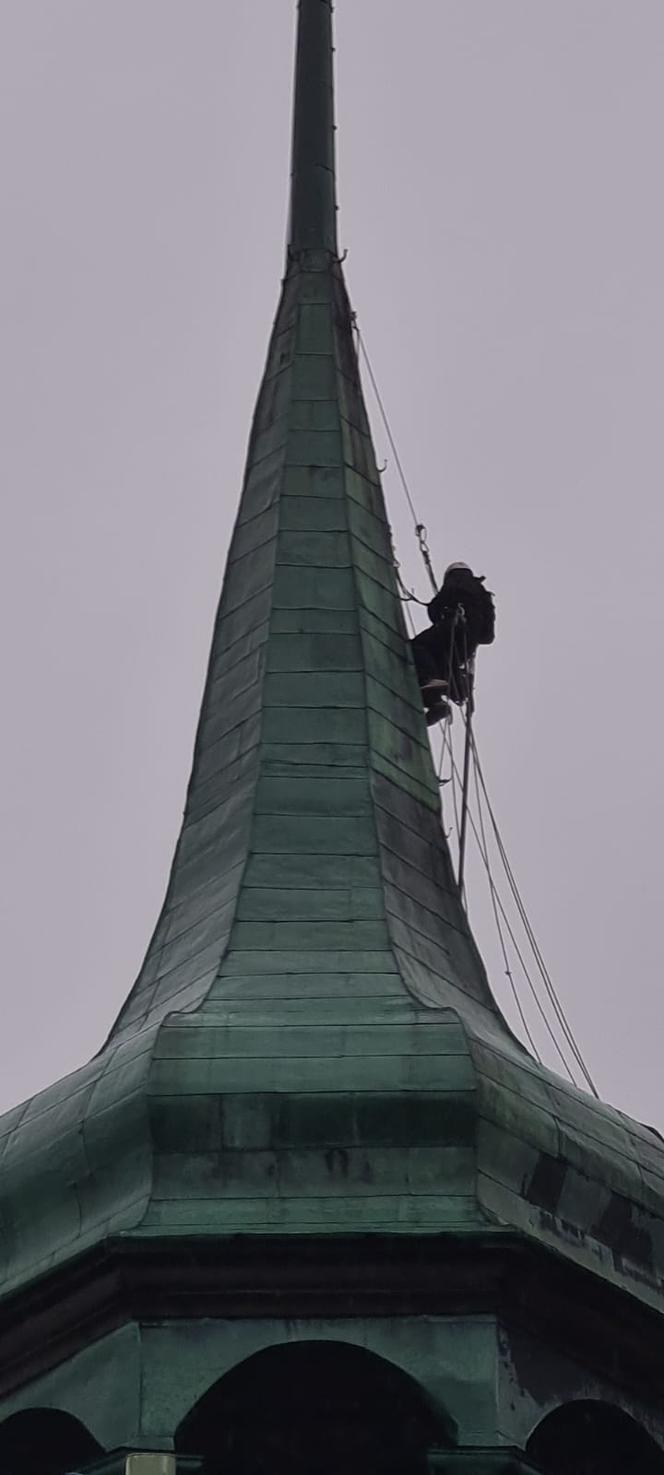 Alpinista na wieży kościoła w Białogardzie