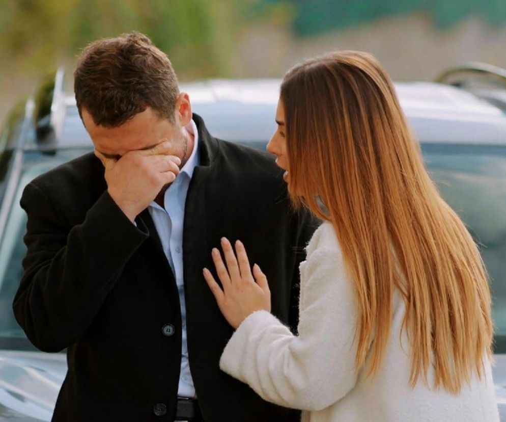 Kuzey ze łzami zasłaniający twarz dłonią, pocieszany przez Silę, która kładzie mu dłoń na klatce piersiowej. Scena z serialu Miłość i Nadzieja, przedstawiająca dramat po wypadku Hulyi. Więcej o ich losach na Super Seriale.