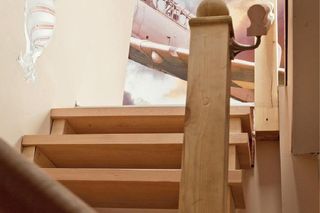 Po drewnianych schodach zabiegowych wchodzi się bardzo wygodnie. Dzięki oknom w połaciach jest na nich jasno. Na szczycie wchodzących wita samolot w chmurach, oczywiście na fototapecie