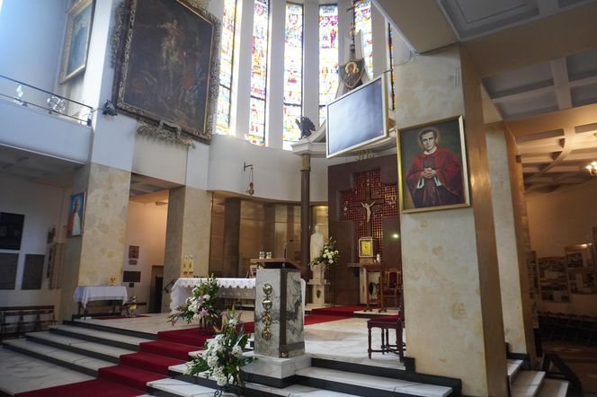 Wnętrze kościoła św. Stanisława Kostki, przed którym znajduje się nagrobek księdza