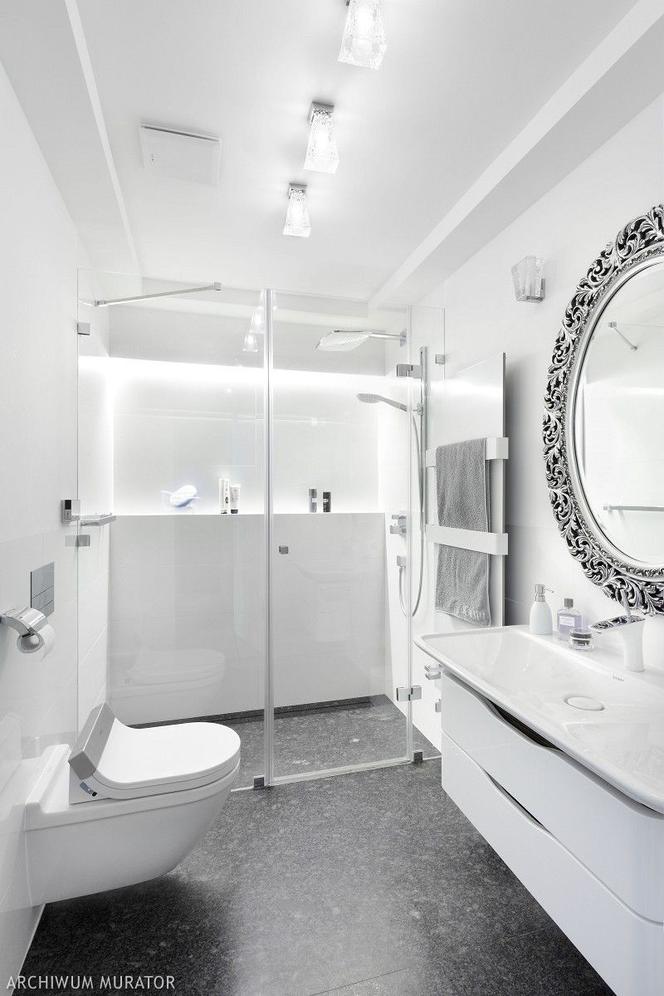 Biała łazienka z dekoracyjnym lustrem