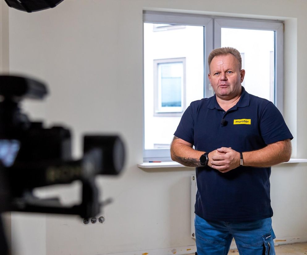 Mężczyzna w koszulce Murator przed kamerą. O hydroizolacji w kuchni przeczytasz na Muratordom.