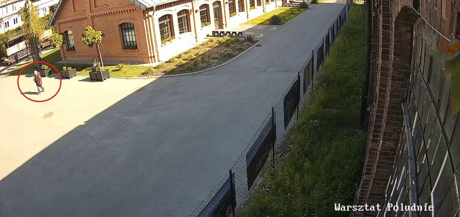 Starsza pani włożyła kwiatek pod pachę i wyszła z terenu Fabryki Pełnej Życia