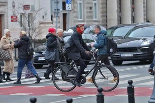 Maciej Gdula na rowerze. Chroni uszy przed chłodem