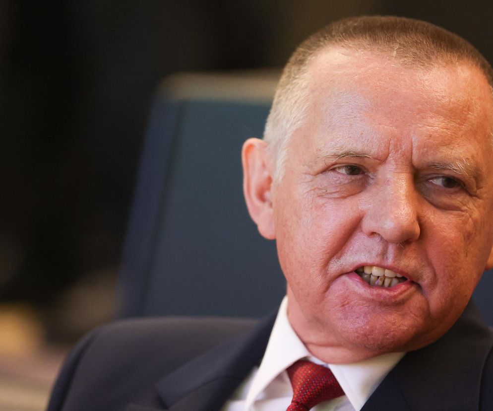 Zbliżenie na Mariana Banasia w garniturze i czerwonym krawacie, z otwartymi ustami, w kontekście gigantycznej odprawy. Jego twarz wyraża emocje związane z zakończeniem kadencji w NIK. Więcej o tej sprawie przeczytasz na Super Biznes.