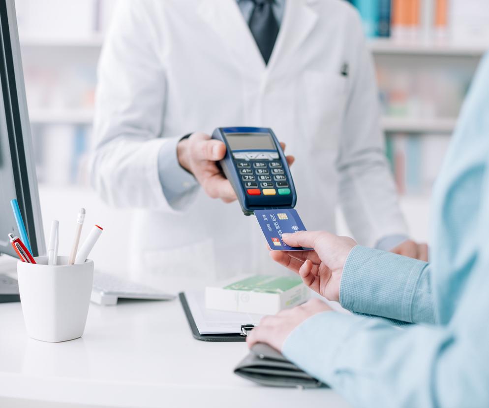 Kobieta płaci kartą w aptece
