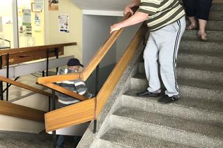 Pacjenci czołgają się po schodach