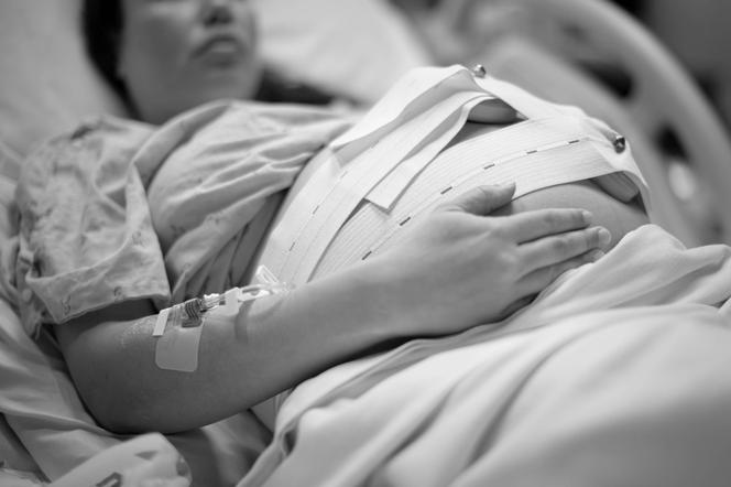 Kobieta w ciąży leżąca w szpitalnym łóżku 