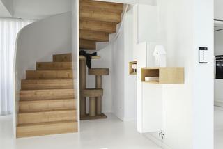 Białe wnętrze z drewnianymi schodami