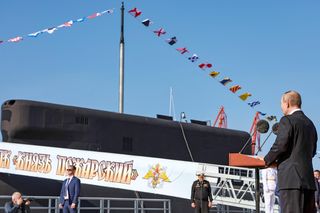 Putin na tle okręty podwodnego Kniaź Pożarski