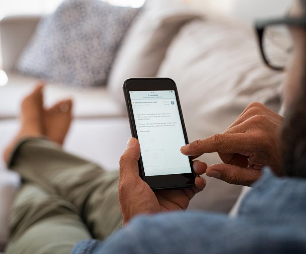 Mężczyzna spogląda na ekran w telefonie