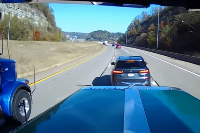Kierowca BMW hamuje przed ciężarówkami