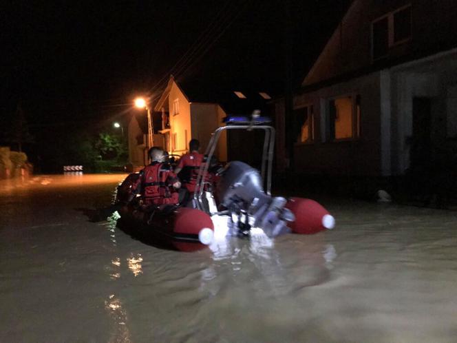 Wóz strażacki z rodziną pod wodą