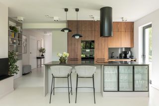 135-m dom architektki w stylu Bauhaus. Kuchnia z fornirem i podłogą z mikrocementu