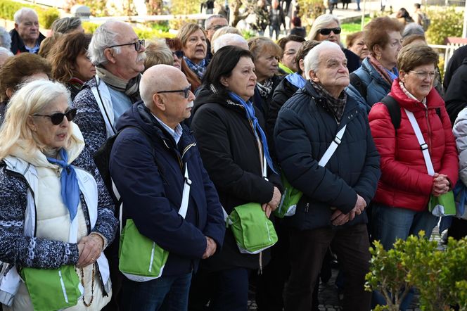 Wierni modlą się o zdrowie Franciszka przed pomnikiem Jana Pawła II. Składają kartki z życzeniami i wiązanki z białych róż