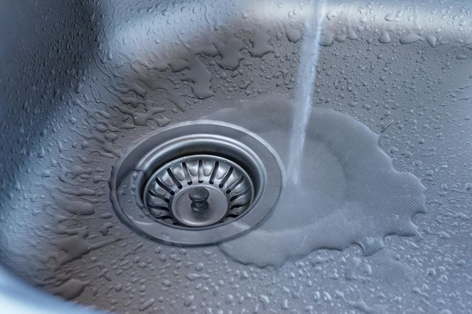 Wpuść 5 kropli do zatkanego odpływu. Woda znowu zacznie do niego spływać jak z wodospadu. Sposób na zatkany zlew 