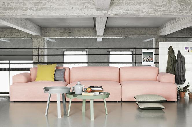 Różowa sofa w industrialnym skandynawskim wnętrzu.