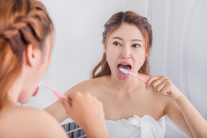 Kobieta myje język szczoteczką