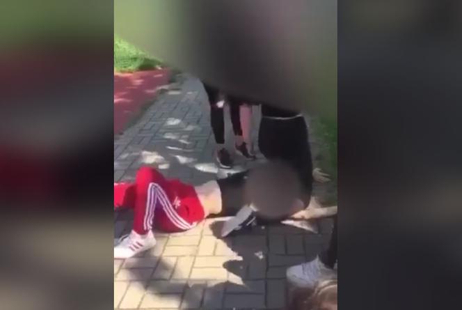 Bójka uczennic. Jedna z nich skacze po rywalce