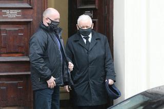 Pięciu ochroniarzy prowadzi Kaczyńskiego do bramy