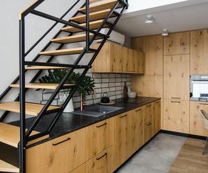 Kuchnię urządzili pod schodami. Zaglądamy do dwupoziomowego apartamentu w stylu eko