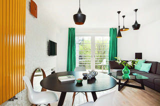 Dwupoziomowe mieszkanie w klimatycznej krakowskiej kamienicy. Prostym meblom towarzyszą kolorowe dodatki