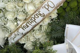 Grób Mareczka z Zabierzowa przykryty pięknymi kwiatami. Czerwone róże przy portrecie chłopca