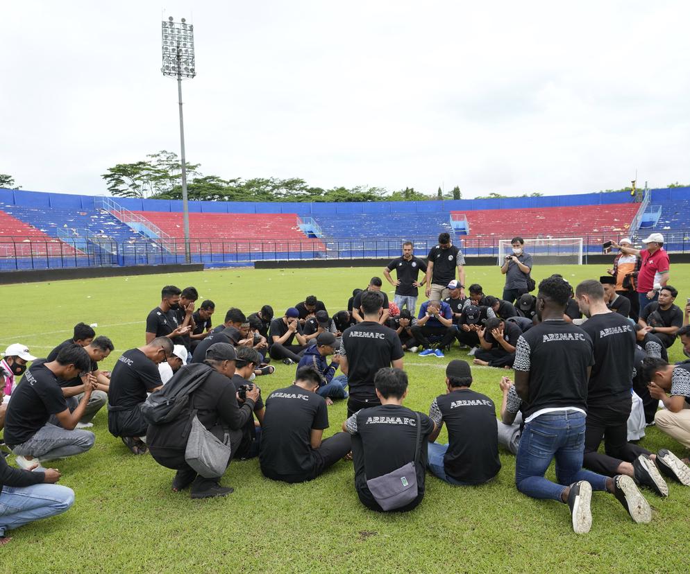Piłkarze i działacze klubu Arema FC modlą się na stadionie w Malangu za ofiary tragedii