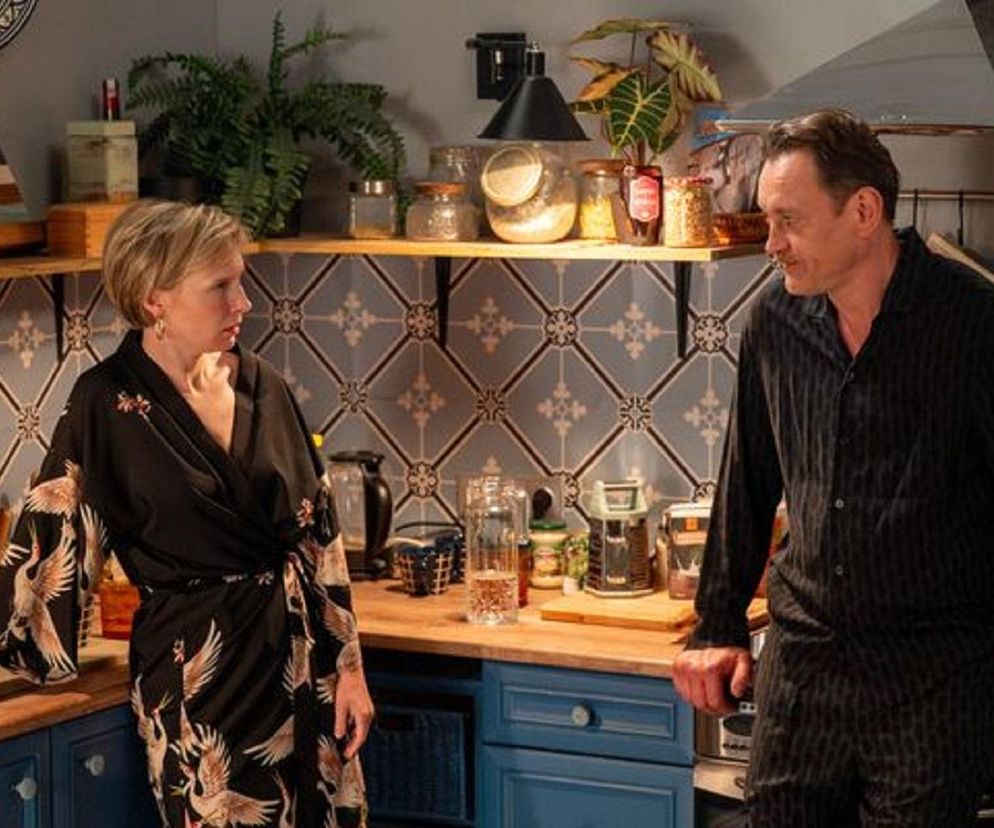 Weronika Nockowska jako Sonia i Paweł Ławrynowicz jako Robert Stefaniak w kuchni w 3264. odcinku Barw szczęścia. Kobieta, ubrana w kimono w żurawie, patrzy na mężczyznę w czarnej piżamie, który stoi z rękami opartymi na blacie. Więcej o ich losach na Super Seriale.