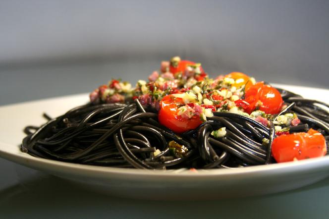Czarny makaron spaghetti z pomidorkami koktajlowymi