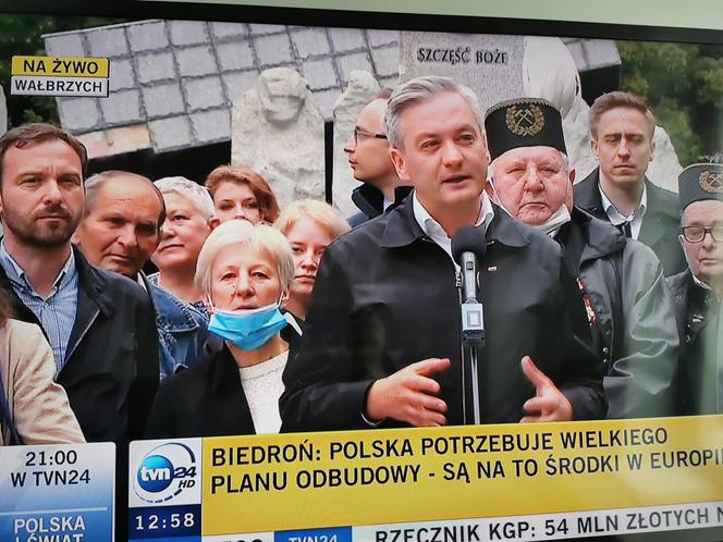 Robert Biedroń na tle religijnego hasła