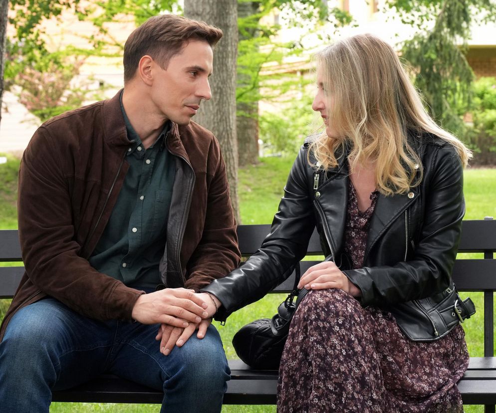 Grażyna (Kinga Suchan) i Tomasz (Jakub Sokołowski) siedzą na ławce w parku, trzymając się za ręce. Ich spojrzenia są skierowane na siebie, wyrażając intymność i bliskość. Więcej o ich losach w serialu Barwy szczęścia przeczytasz na Super Seriale.