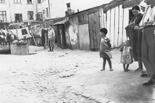 Bezdomni z dziećmi przed swoimi prowizorycznymi mieszkaniami na jednym z łódzkich podwórek, 1918 - 1934 