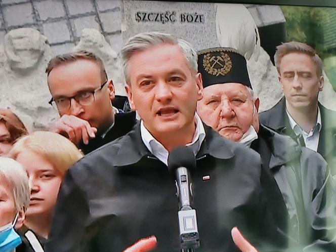 Robert Biedroń na tle religijnego hasła