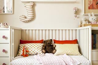 Tkaniniy w rożnych kolorach wzorach na łóżku w pokoju dziecięcym