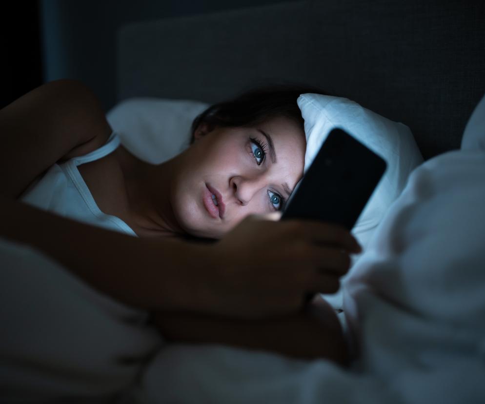 Kobieta korzysta z telefonu w nocy