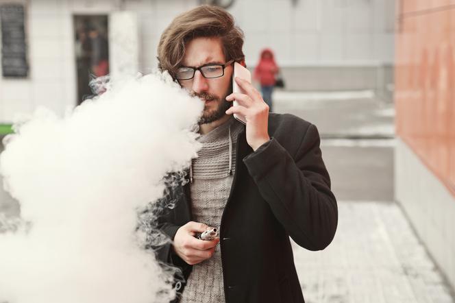 Mężczyzna pali e-papierosa