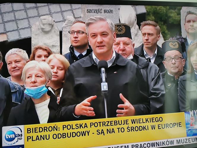 Robert Biedroń na tle religijnego hasła